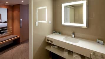 Un bany modern amb un mirall gran, un lavabo i un suport per a tovalloles.