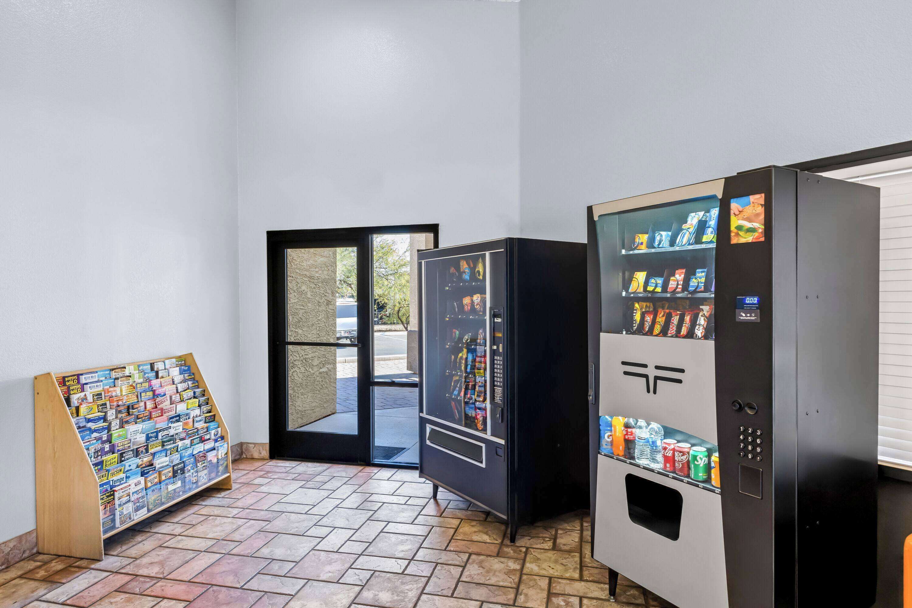Ein Getränkeautomat, ein Zeitschriftenständer und eine Tür in einem Gang.