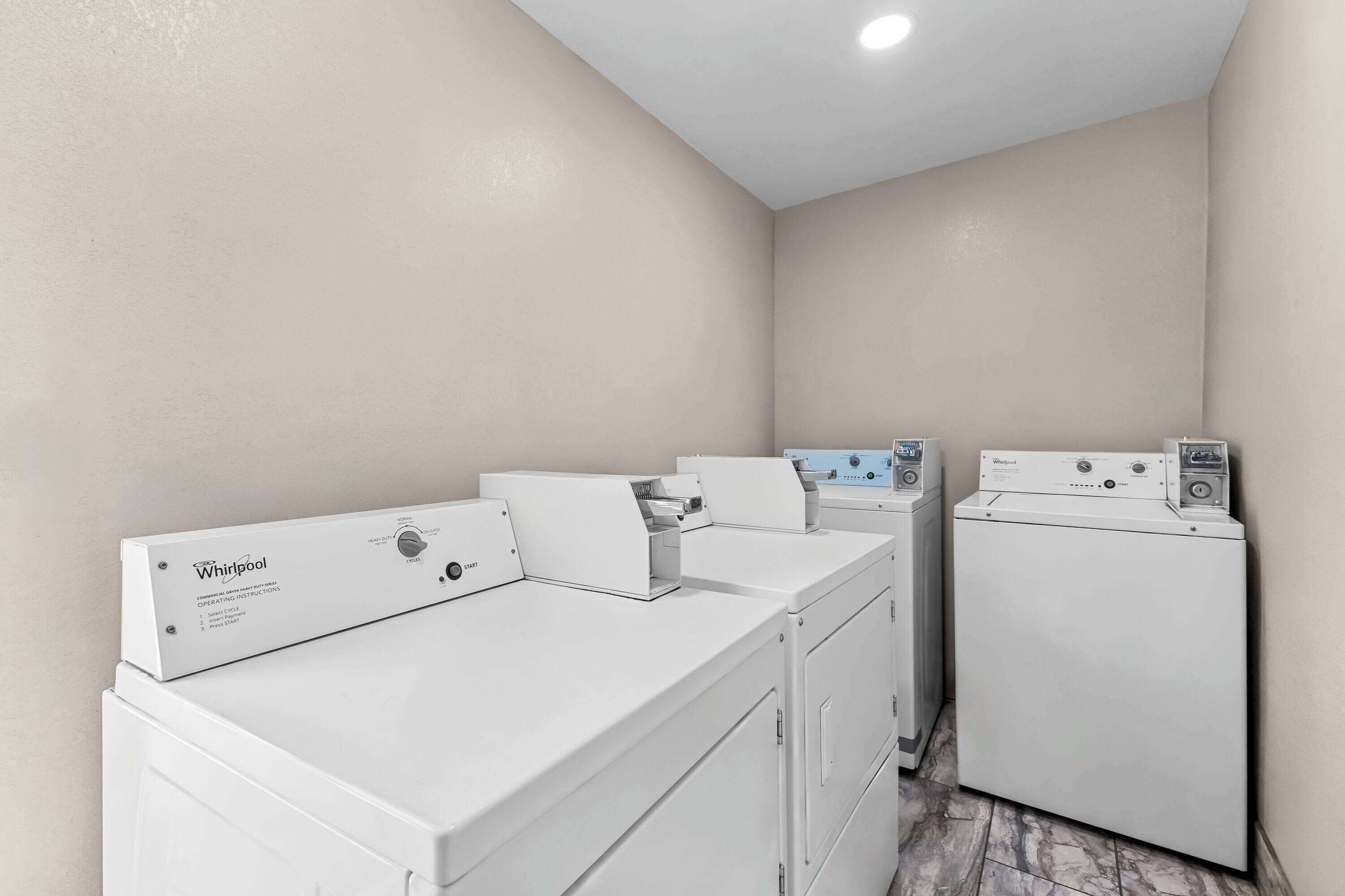 Un área de lavandería con lavadoras y secadoras Whirlpool.