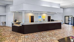 A reception area with a modern design, featuring a black reception desk, a tiled floor, and a large window. - Days Inn by Wyndham Buckeye (Buckeye)