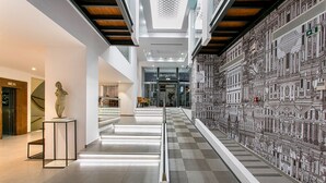A modern interior with a checkered floor, a sculpture, and a detailed wall mural.
