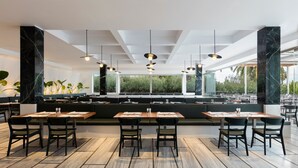 A modern restaurant with a long counter, black marble columns, and wooden flooring. - Kassandra Palace Seaside Resort (Kassandra)