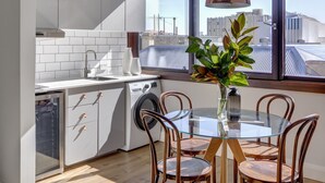 Una cocina moderna con comedor, ventanas amplias y vista a la ciudad.