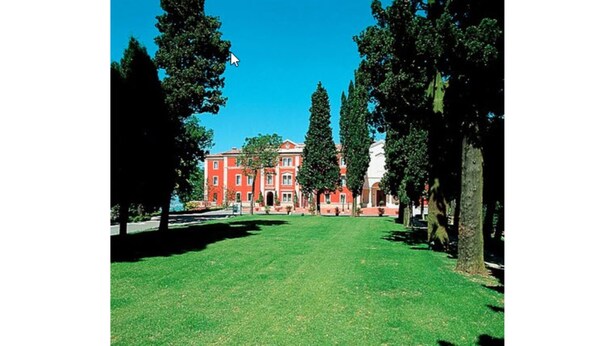 A large red building with a lawn in front. - Hotel Monte del Re (Dozza)