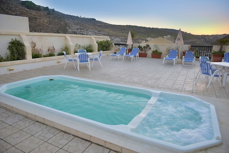 Una piscina al aire libre, sillones reclinables de piscina