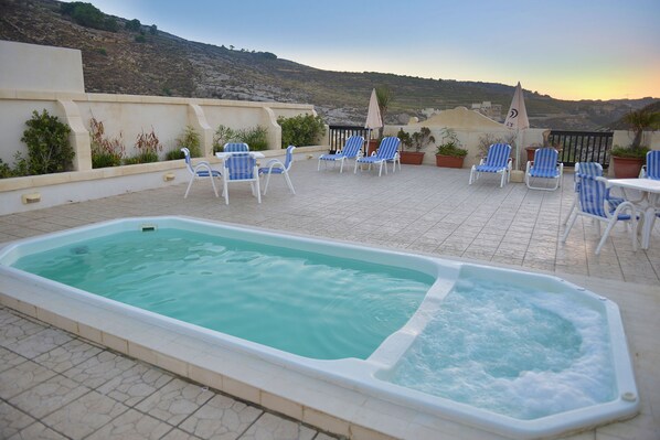 Una piscina al aire libre, tumbonas