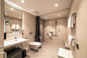 A modern bathroom with a sink, toilet, mirror, and shower. - Stadthotel Münster (Münster)