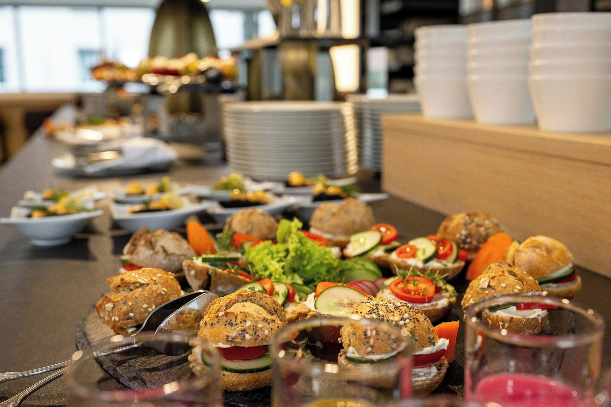 Ein Buffet mit verschiedenen Speisen, darunter Sandwiches und Salate.