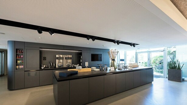 A modern kitchen with a large island, built-in appliances, and a large window providing natural light. - Stadthotel Münster (Münster)
