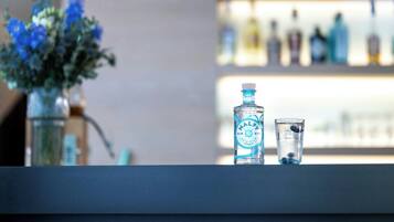 Eine Bar mit einer Flasche Gin und einem kleinen Glas.