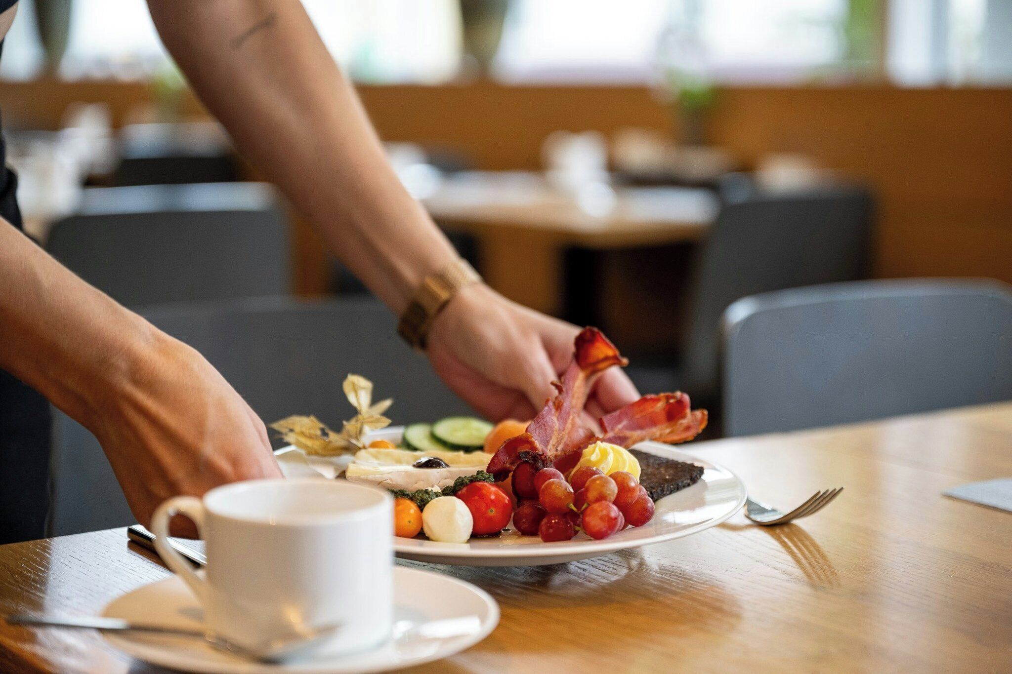 Une table à manger avec une assiette de nourriture, une tasse et une fourchette.