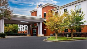 Ein Hotel mit Eingangsbereich, überdachter Auffahrt und blauem Himmel.