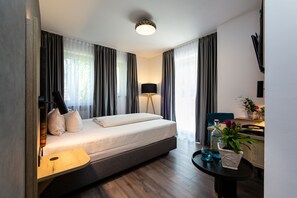 Deluxe eenpersoonskamer | Luxe beddengoed, een minibar, een kluis op de kamer, een bureau