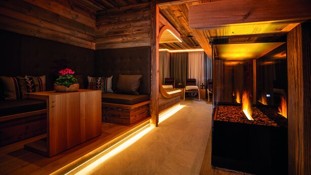 A cozy room with a fireplace, wooden furniture, and a seating area. - ARCUS HOTEL MÜNCHEN MESSE (Vaterstetten)