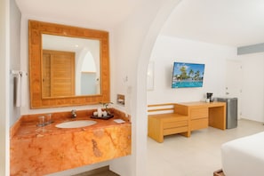 A bathroom with a marble sink, wooden vanity, and a large mirror.