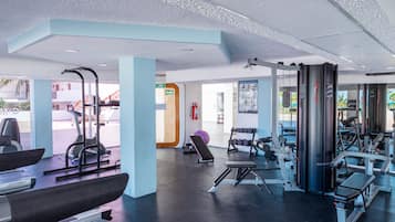 Une salle de sport moderne équipée de machines de cardio, de poids libres et de divers appareils d’entraînement.