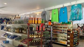 Una tienda con estantes llenos de diversas bebidas, incluyendo licores y conservas.