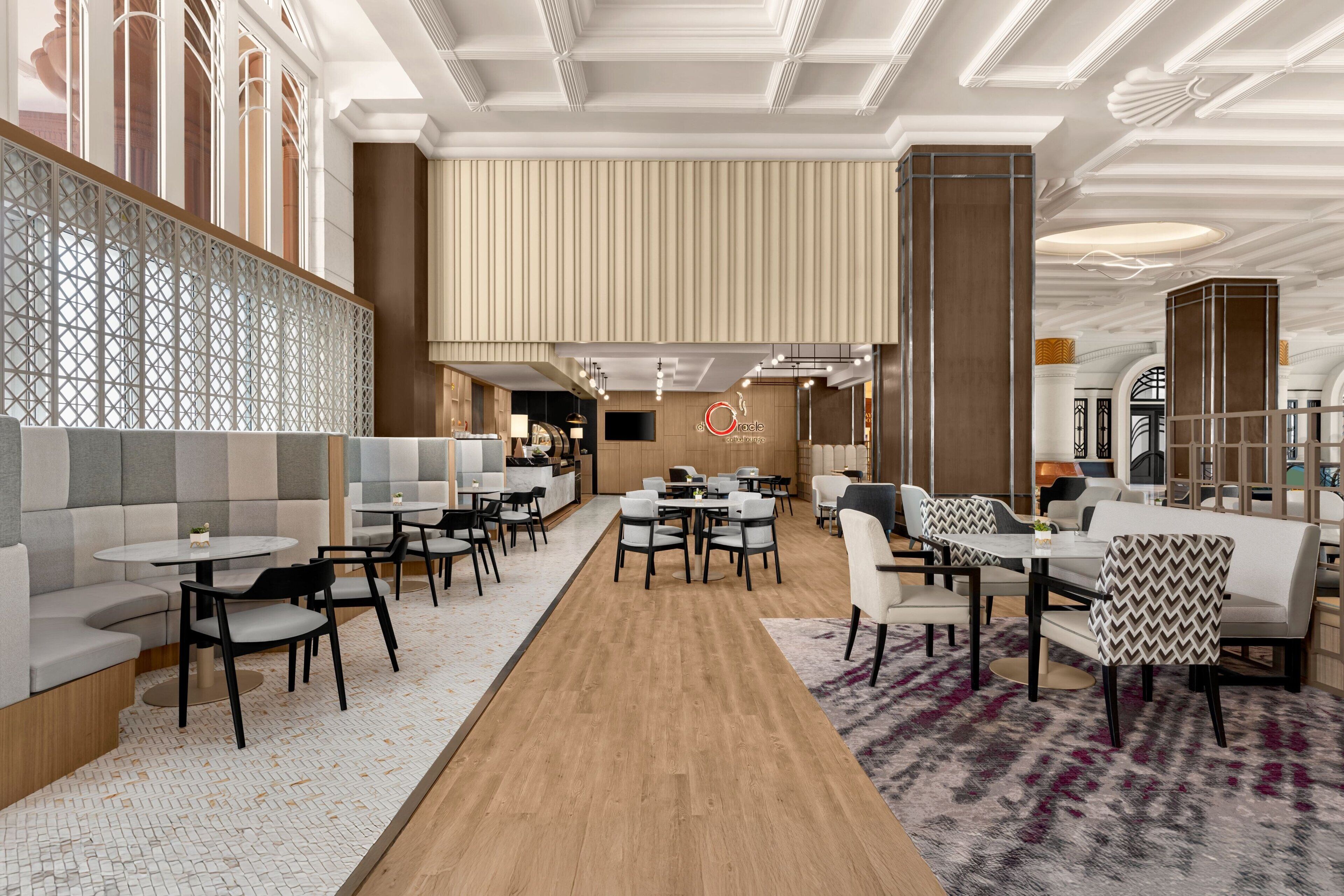A modern restaurant with booths, round tables, and a central bar area.