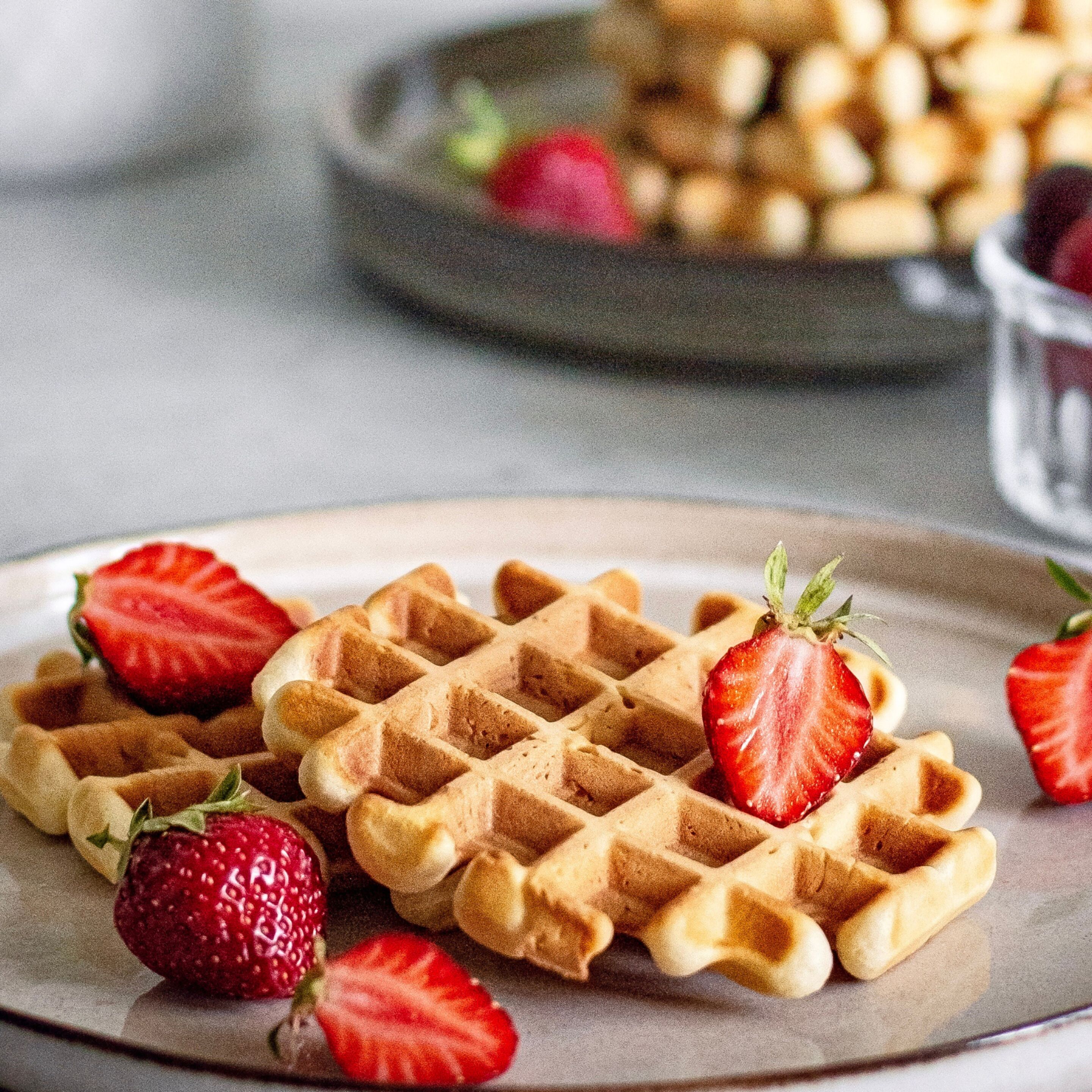A plate of waffles with strawberries.
