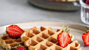 A plate of waffles with strawberries.