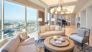 A spacious living room with a large window offering a city view, a round coffee table, and a modern chandelier. - JW Marriott Surabaya (Surabaya)
