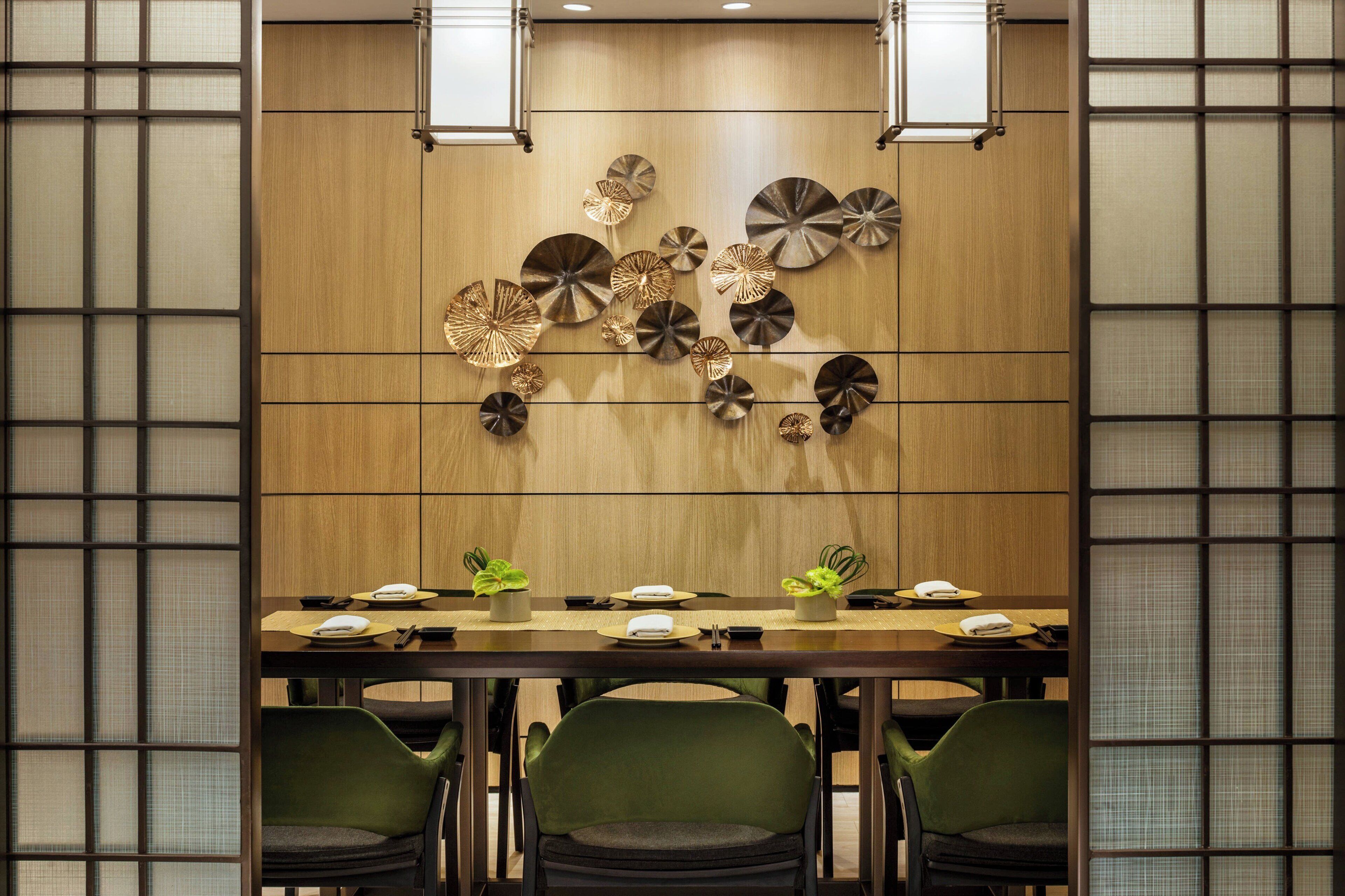 A conference room with a long table, four chairs, and decorative wall art.