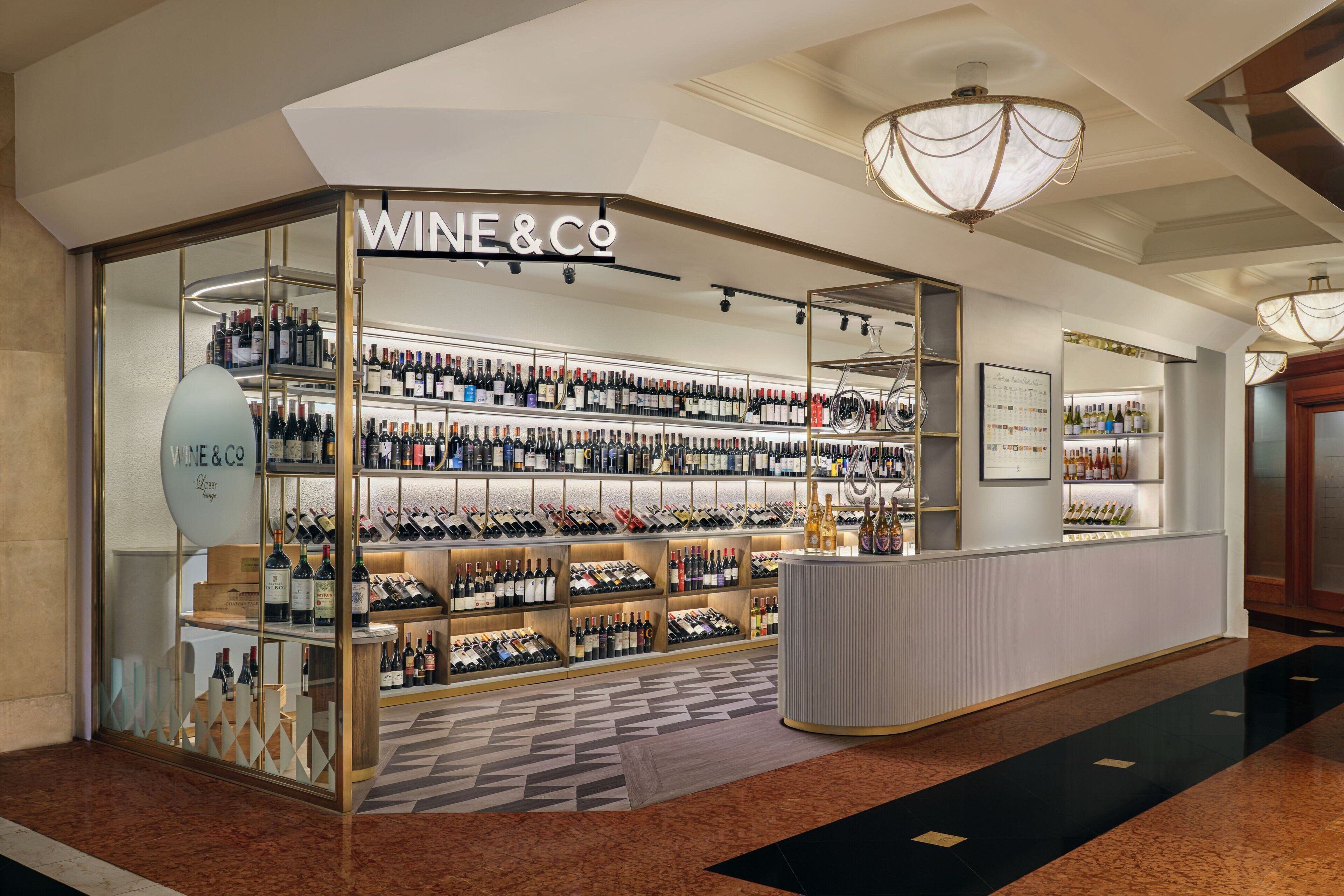 A wine and spirits store with shelves of bottles, a reception area, and a patterned floor.