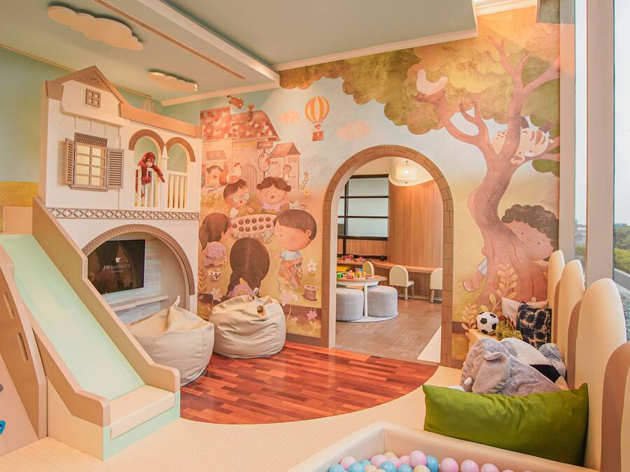 A children's play area with a slide, climbing wall, and seating.