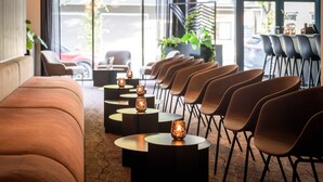 Un interior moderno con un sofá, sillas, mesas y luces decorativas.