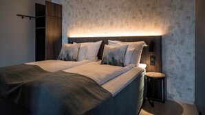 Un dormitorio moderno con una cama grande, una mesita de noche y un armario.