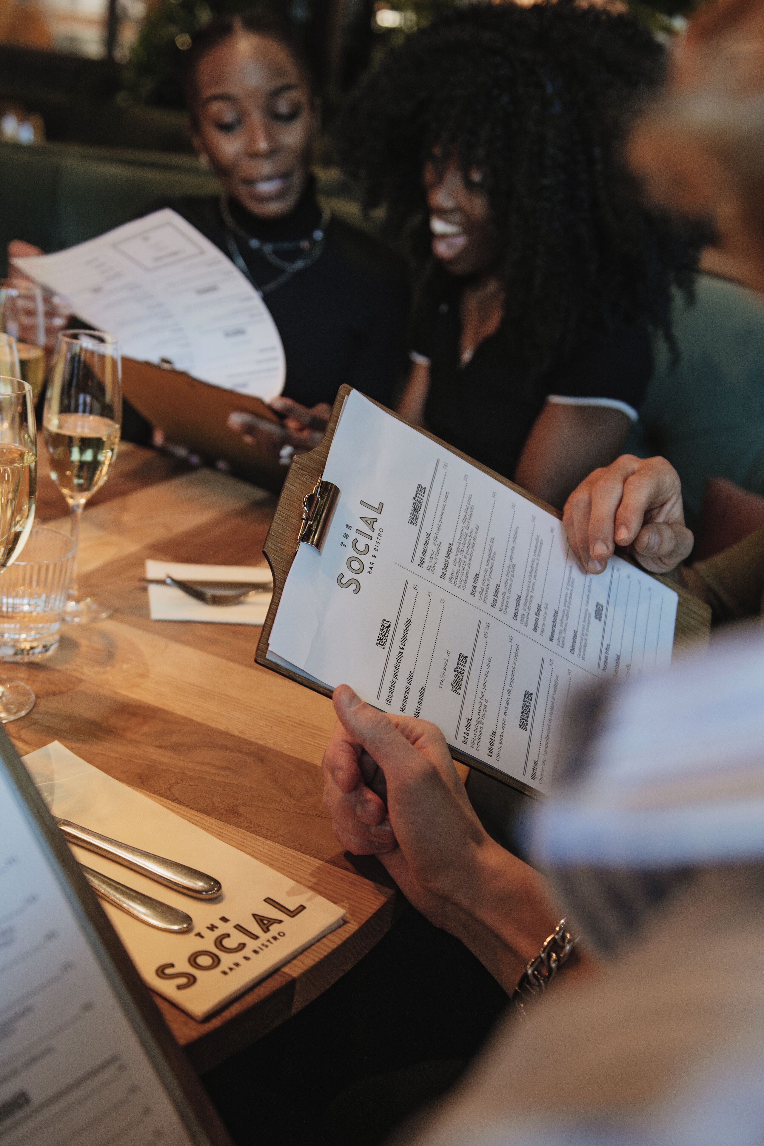 A menu with the title "The Social" on a wooden table.
