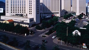 A multi-story hotel with a prominent entrance and a parking area. - Beijing Landmark Hotel (Beijing)