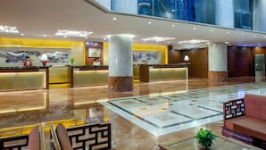 A hotel lobby with marble floors, a reception desk, a sofa, and a coffee table. - Beijing Landmark Hotel (Beijing)