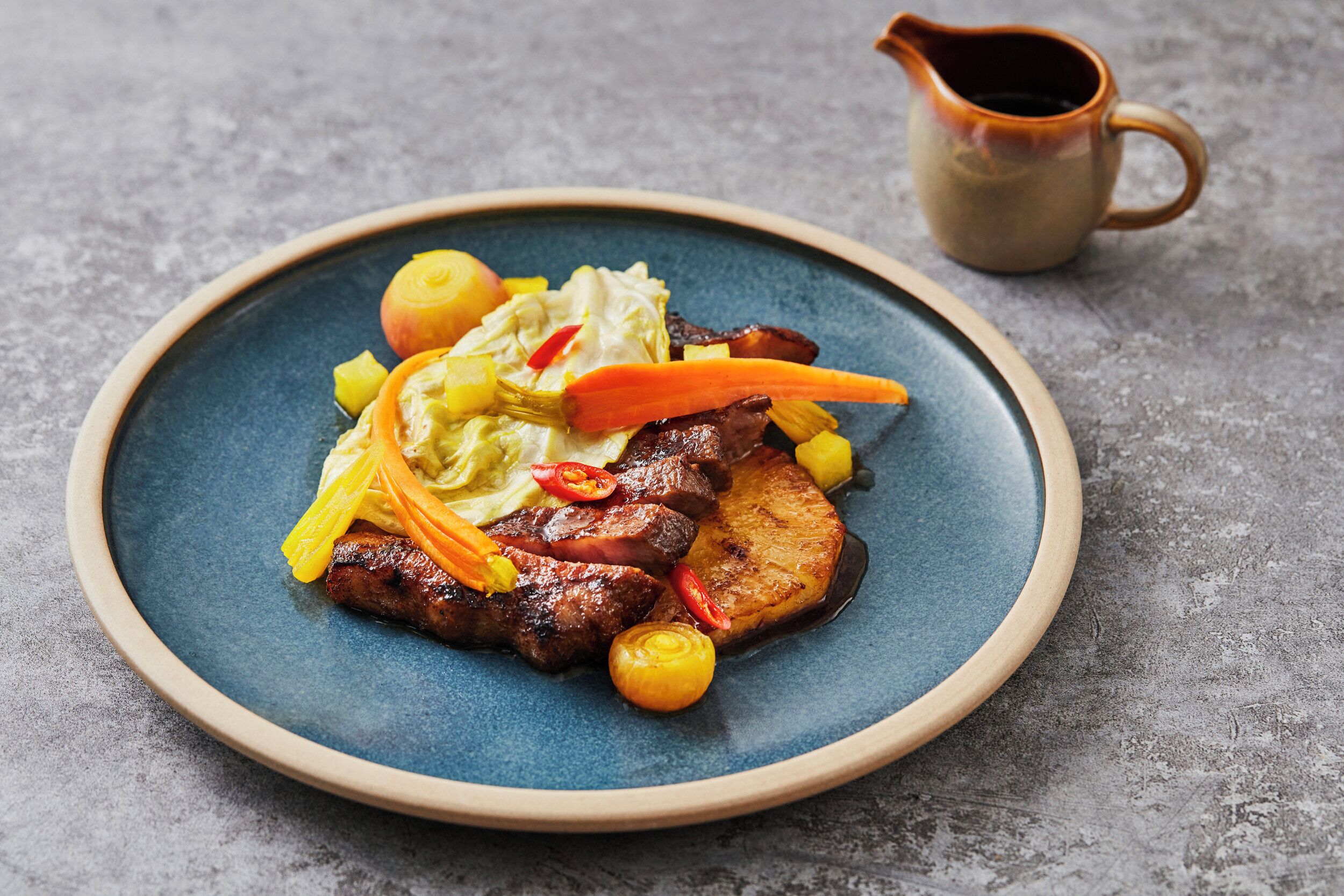 Une assiette de nourriture avec une carafe en arrière-plan.