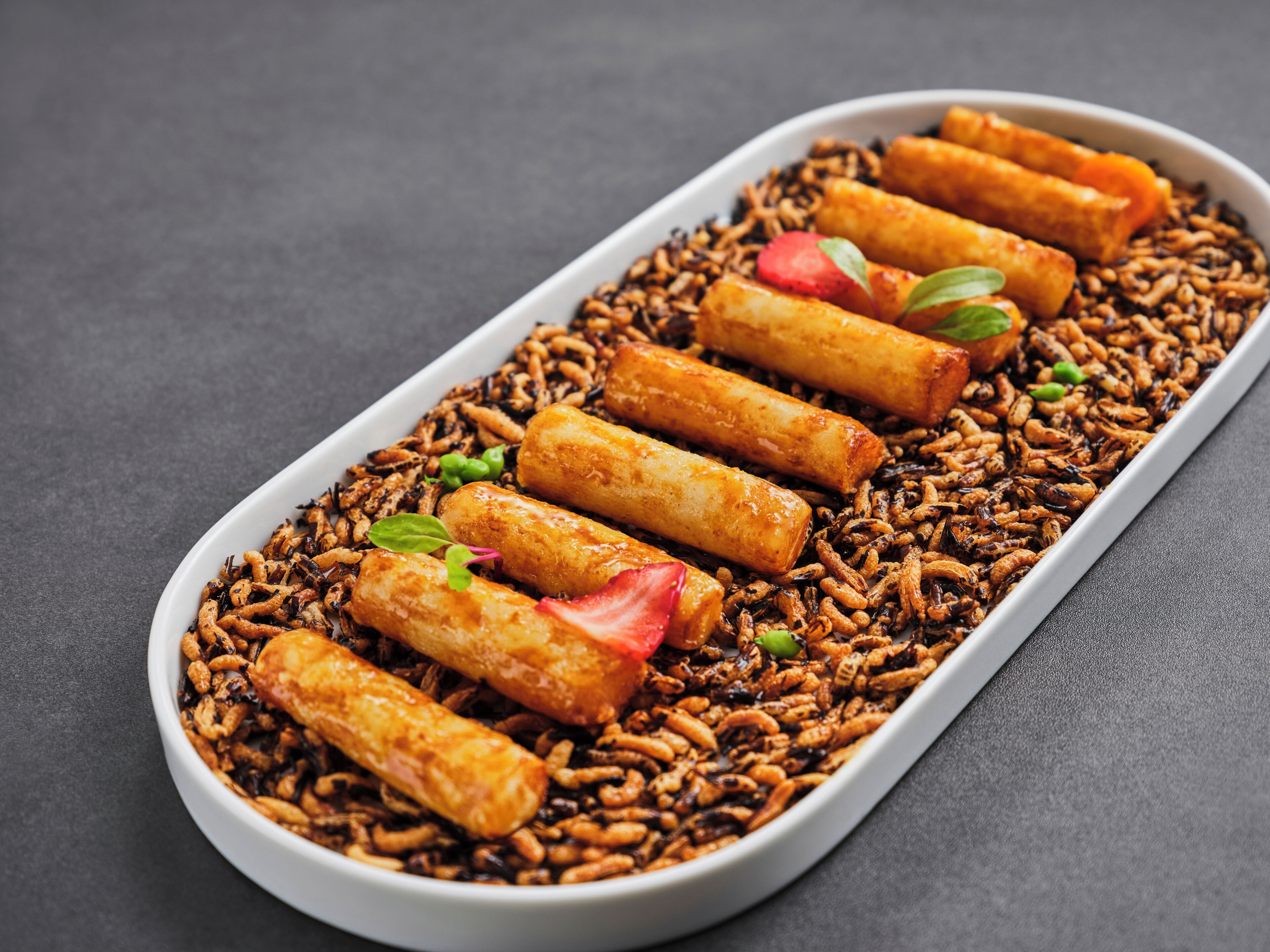 A dish with fried items and noodles on a white plate.