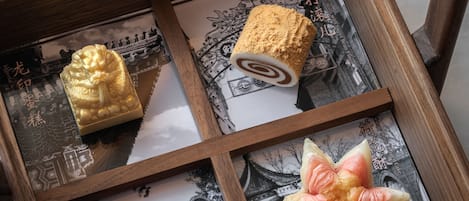 Una caja de madera con diversos pasteles y un adorno.