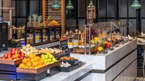 Un bufé con diversas frutas, verduras y platos preparados.