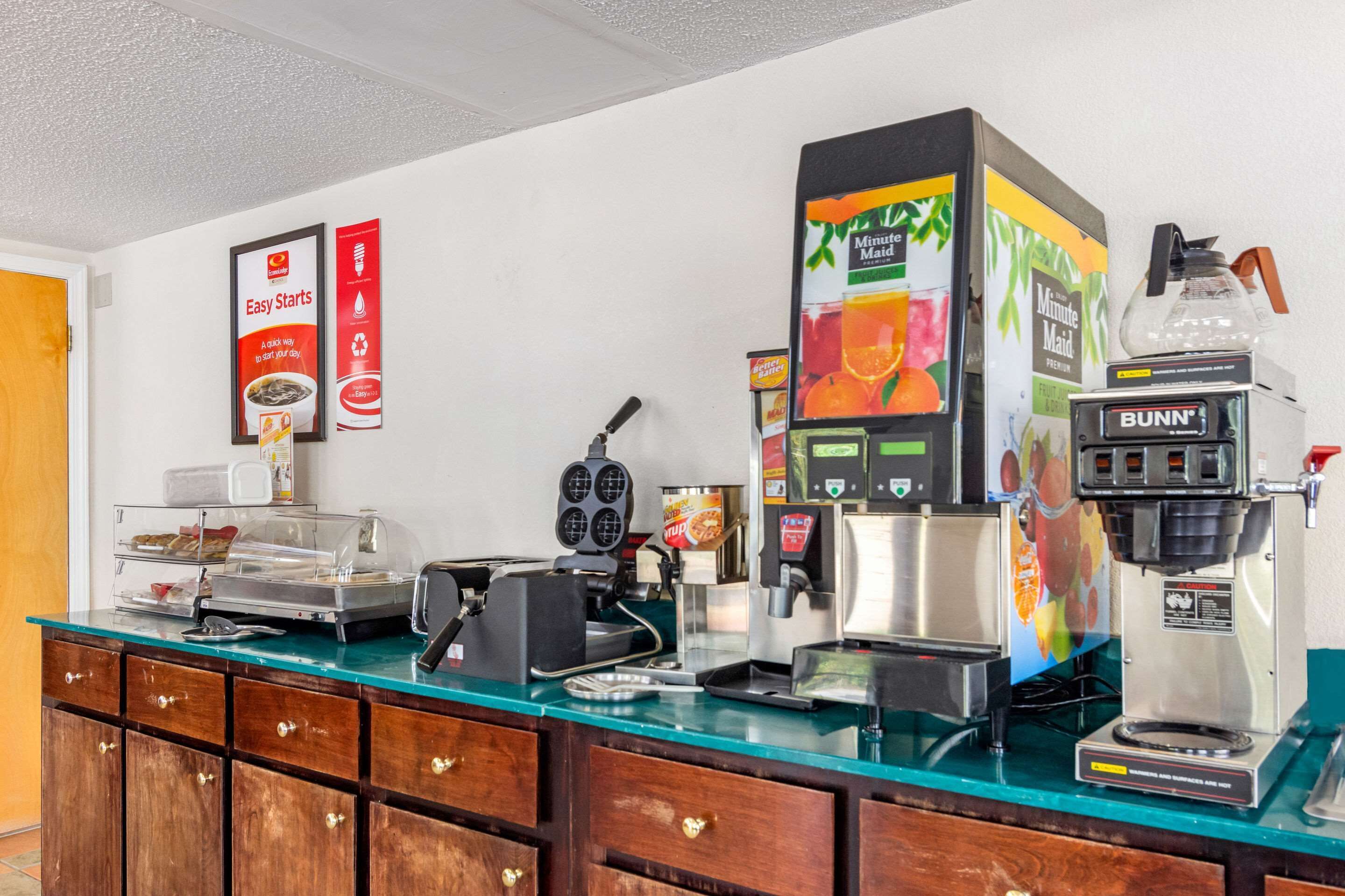 A self-service coffee station with various coffee machines and a food display.