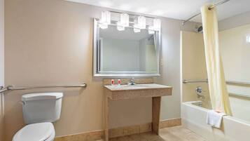 Un baño con inodoro, lavamanos, espejo y bañera.