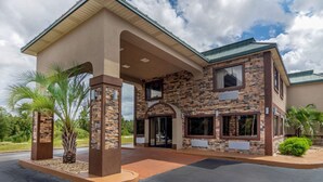 A building with a stone facade, large windows, and a covered entrance area.