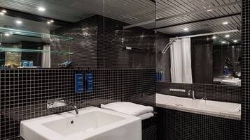Een moderne badkamer met een groot, wit bad, een apart wastafelmeubel en een douchehoek.