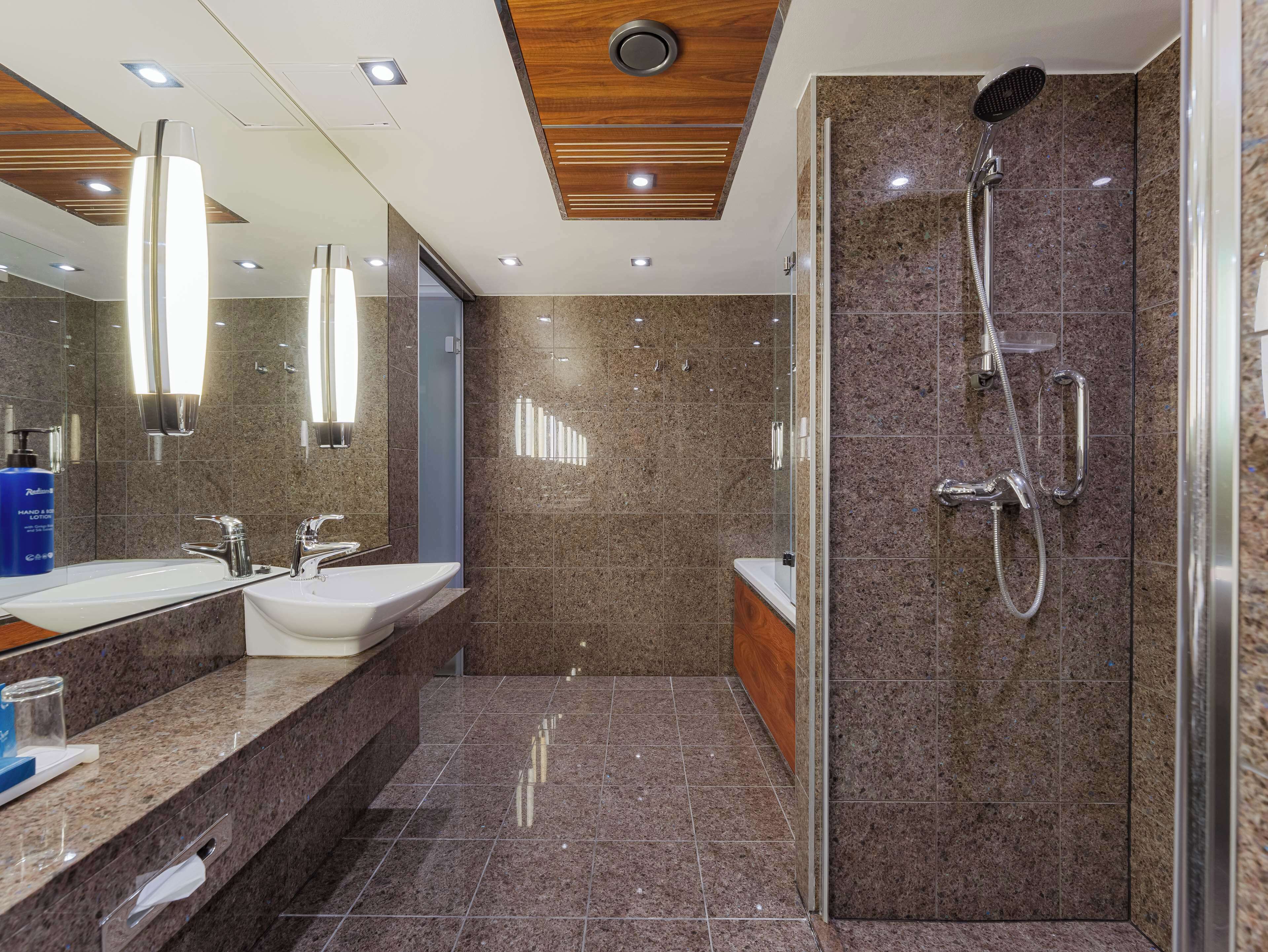 A modern bathroom with a shower, sink, and vanity.