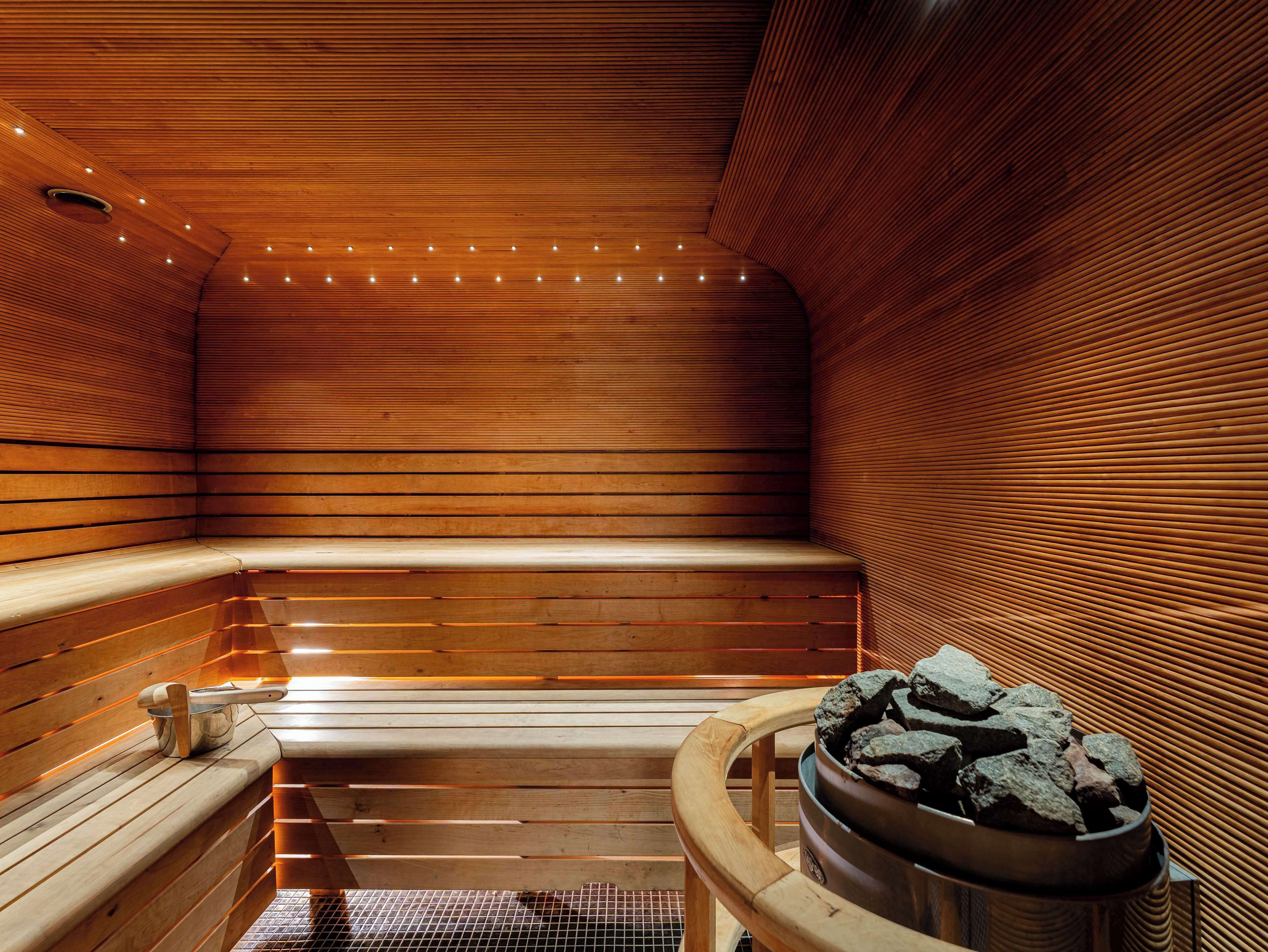 En sauna med træbænke og en stentønde.