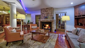 Amplia sala de estar con chimenea de piedra, sofás de cuero y una mesa de centro grande.