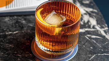 Un vaso con un cubito sobre una mesa de mármol.