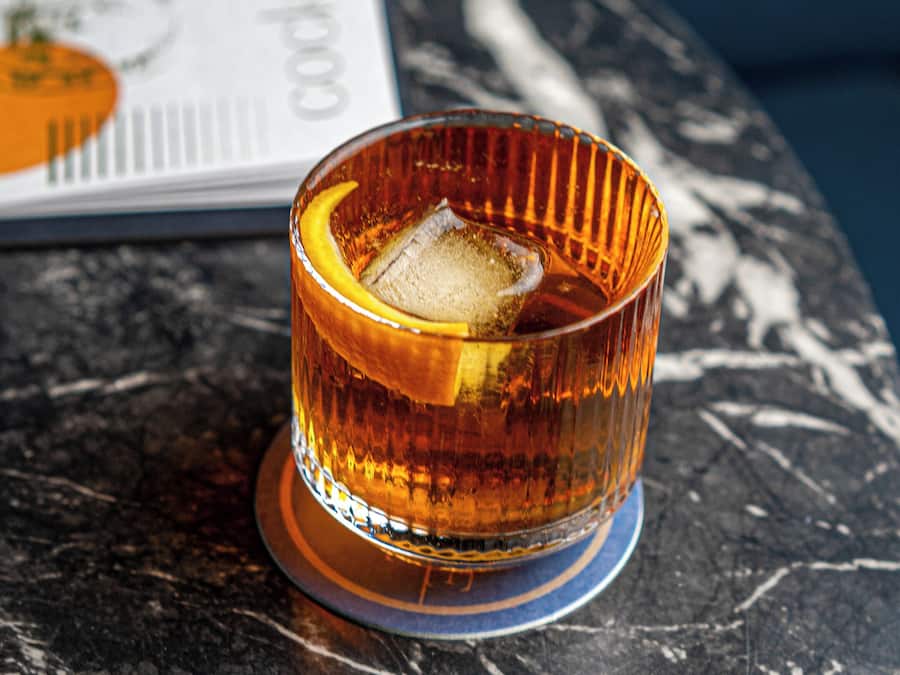 Un vaso con un cubito sobre una mesa de mármol.