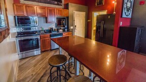 A kitchen with wooden cabinets, stainless steel appliances, and a long countertop. - River Hills Hotel (Mankato)