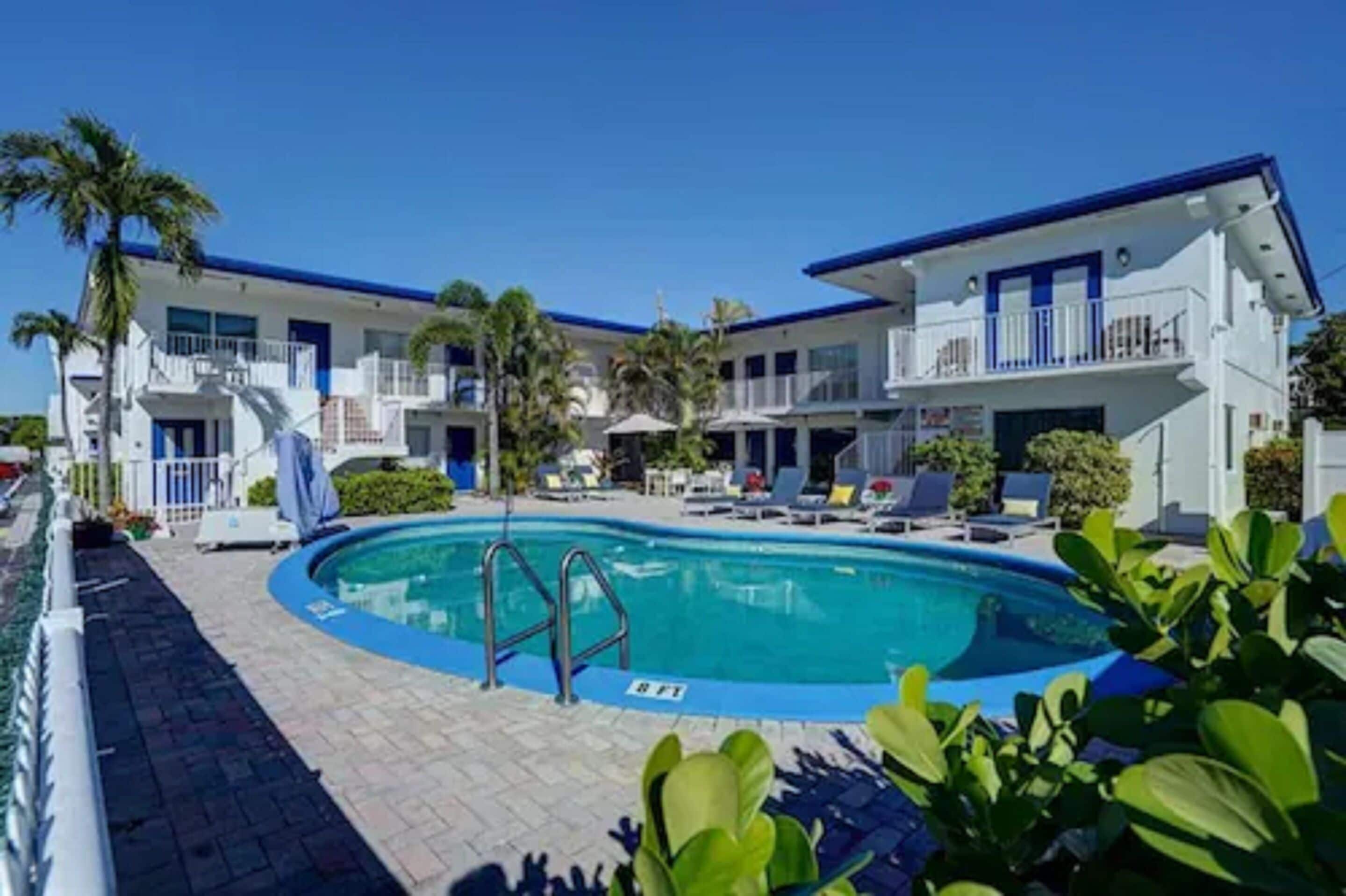Ein Hotel mit Poolbereich, inklusive Liegestühlen und einer Poolleiter.