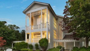 A two-story house with a balcony, a garage, and a well-maintained garden.
