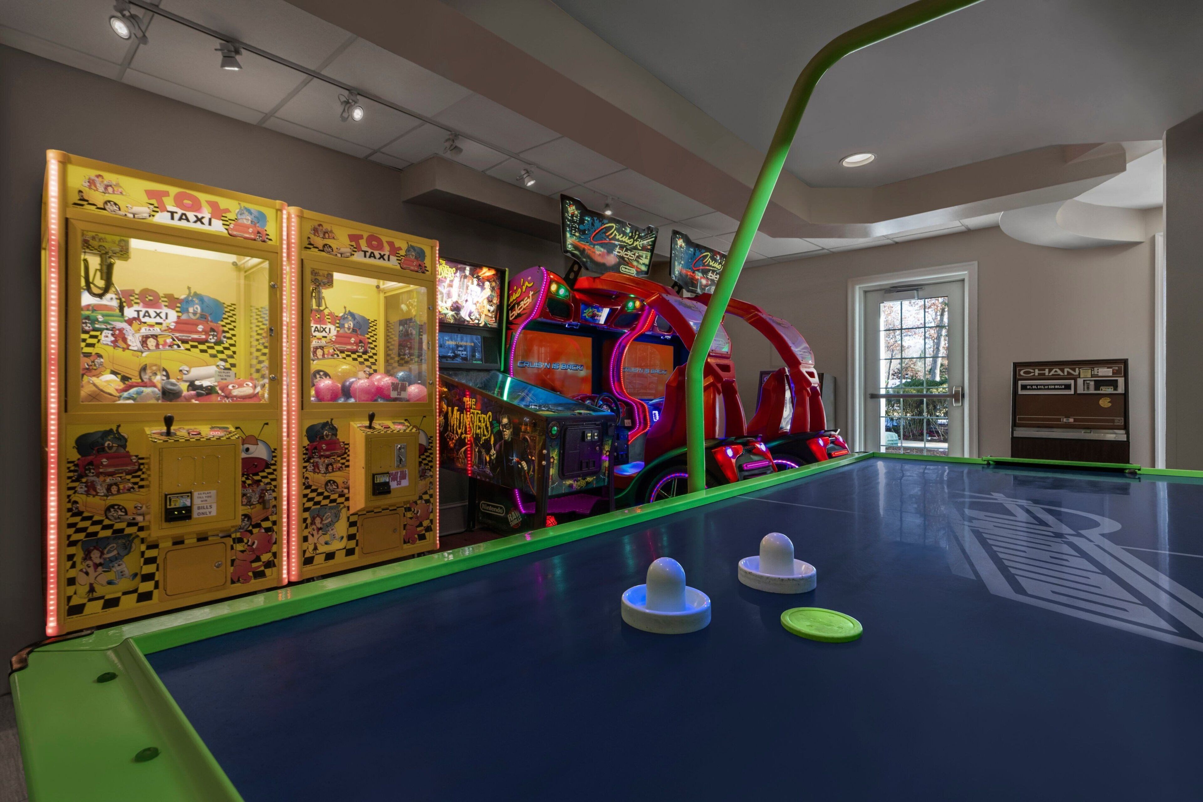 An indoor arcade with colorful games and a pool table.